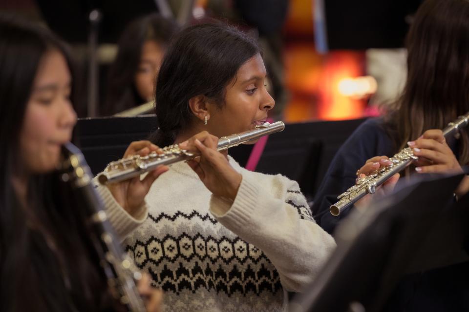 Middle school student playing flute in music class. 