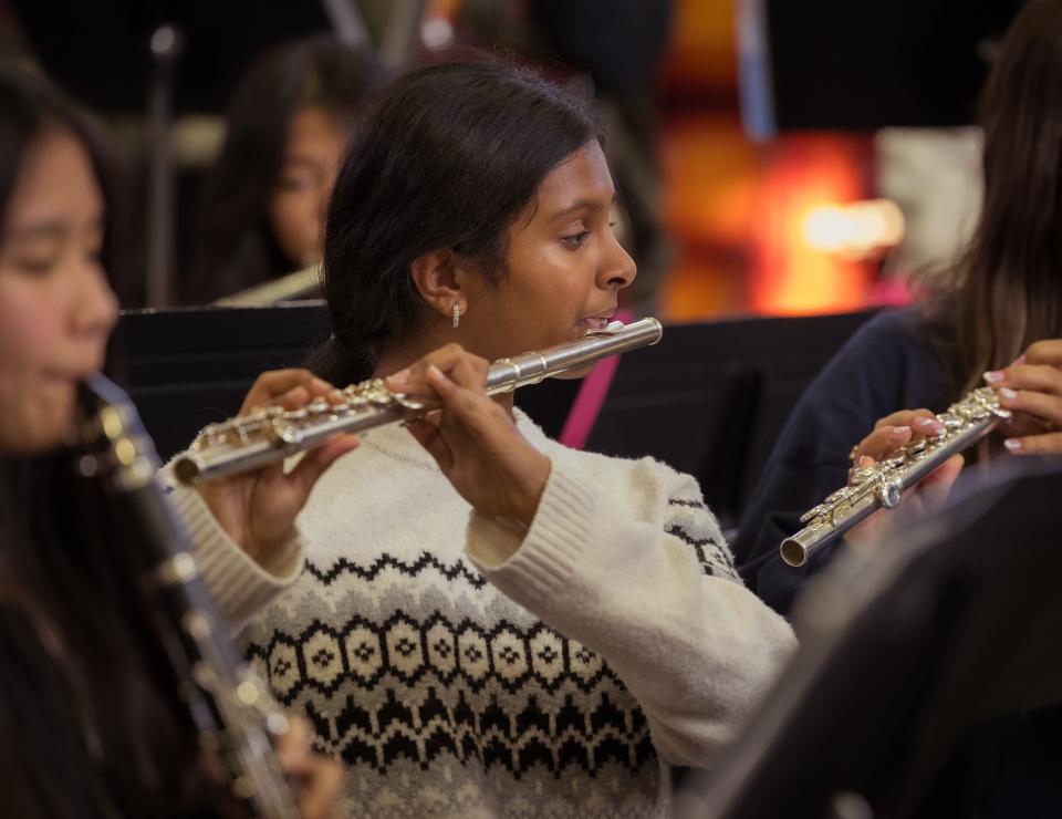 Middle school student playing flute in music class. 